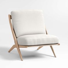 an upholstered chair with wooden legs and a white fabric seat pad on the back