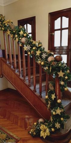 a staircase decorated with christmas garland and ornaments