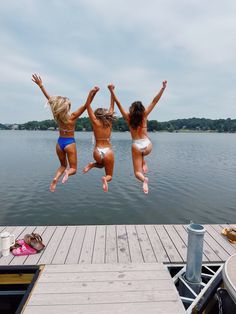 two girls jumping into the water from a dock