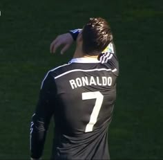 a man in black jersey standing next to a soccer ball