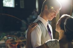 a man and woman standing next to each other in front of a light shining on them