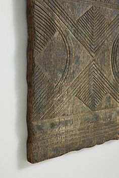 a piece of wood that has been carved into a wall hanging on the side of a white wall