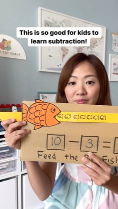 a woman holding up a cardboard sign that says, this is so good for kids to learn subtraction