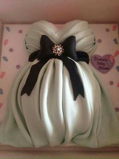 a cake in the shape of a dress with black and white bows on it's head