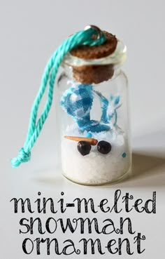 a glass jar filled with snowman ornament on top of a white table