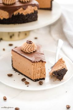 a slice of chocolate cheesecake on a plate with the rest of the cake in the background