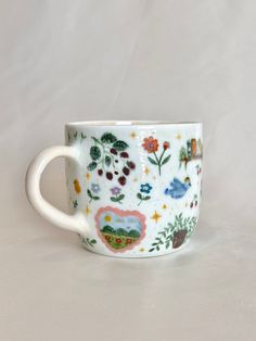 a white cup with colorful designs on it