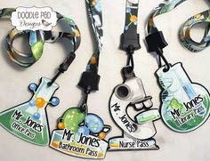 three lanyards with name tags attached to them on a white surface, one has a camera and the other has two lanyards