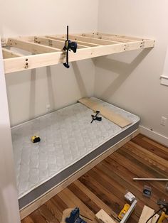 a bed frame is being built in a room with hard wood flooring and tools