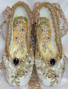 pair of white and gold ballet shoes with beaded details