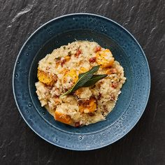 a blue bowl filled with food on top of a table