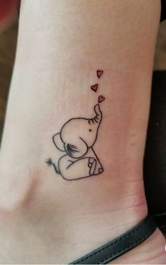 a small elephant tattoo on the side of a woman's leg with hearts coming out of its trunk