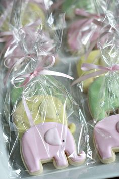 decorated cookies in plastic wrappers with pink and green elephants on them, tied together