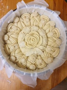 a bowl filled with cookies sitting on top of a wooden table covered in plastic wrap