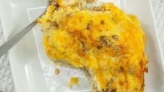 a white plate topped with a cheesy casserole covered in meat and cheese