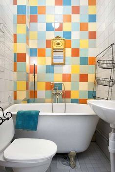 a bath room with a toilet and a bath tub next to a sink under a mirror