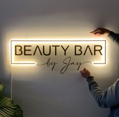 a woman holding up a sign that says beauty bar by jayy