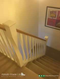 an empty staircase with white handrails and beige carpeted flooring in a home