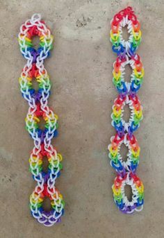 two rainbow loom bracelets sitting next to each other on a cement surface,