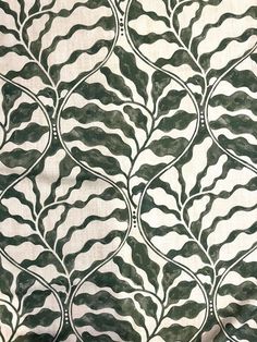 the fabric is green and white with black swirls on it's sides, as well as an abstract design