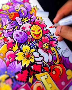 a person is drawing with colored pencils on a piece of paper that has flowers and numbers