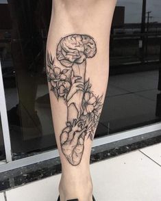 a woman's leg with a black and white tattoo on it