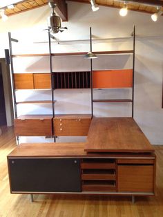 an office desk with shelves and drawers on the top, in front of a wooden floor