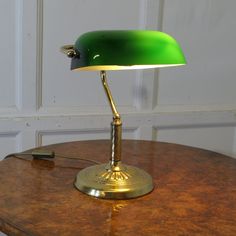 a green lamp sitting on top of a wooden table