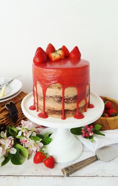 a cake with strawberries is sitting on a table