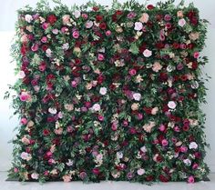 an artificial flower wall is the focal point for this photo