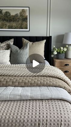 a large bed with pillows and blankets on it's headboard in a bedroom