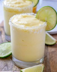 two margaritas sitting on top of a wooden table