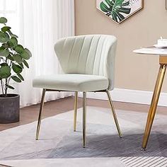 a white chair sitting on top of a rug next to a table