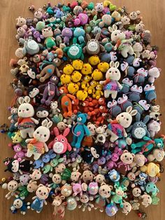 a pile of stuffed animals sitting on top of a wooden floor