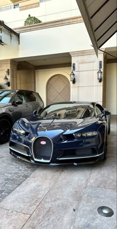 two bugatti cars parked in front of a building with an open garage door