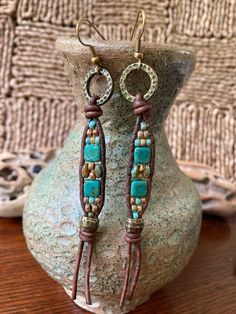 "These long hanging Boho Style earrings are made with green turquoise/brown Duets SuperDuo Beads, along with Czech Glass Picasso Tile beads. They have been accented with Picasso Seed Beads. I have also added TierraCast Barrel Crimp beads and ring, all which has been beaded onto brown leather. There is an antique brass tone french earwire for ease of wearing. These earrings measure just about 4\" inches long, which includes the attached earwire. See picture. They are 3/8\" inch wide at the beaded portion, and the TierraCast Ring, is 1/2\" inch wide. These are very lightweight, and move freely. Free shipping in the US.  Thanks so much for looking!" Leather Earring Ideas, Superduo Beads, Boho Jewelry Diy, Sea Earrings, Diy Jewelry Rings, Nature Craft, Handmade Boho Jewelry, Boho Style Earrings, Leather Earring