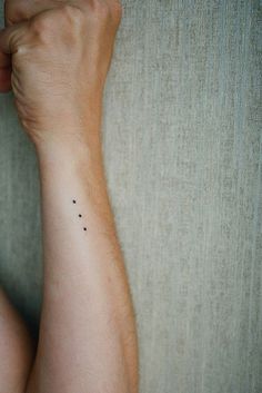 a person's arm with a small tattoo on the left side of their arm