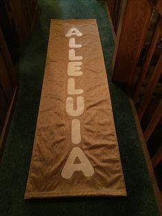 a brown towel with the word alaska on it is laying on a green carpeted hallway