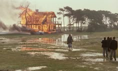 people walking in front of a house on fire