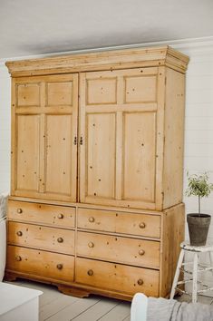 a large wooden cabinet sitting in the corner of a room