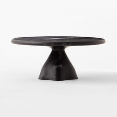 a black cake plate sitting on top of a white table