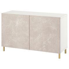 a white cabinet with gold legs and a marble pattern on the front, against a white background