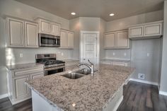 an empty kitchen with granite counter tops and stainless steel appliances