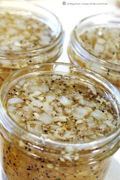 four jars filled with food sitting on top of a table