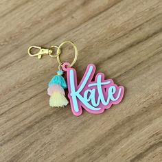 a keychain with the word kate written in pink, blue and yellow on it