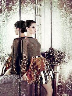 two women standing in front of a mirror with their backs turned to the same direction