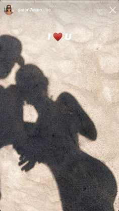 the shadow of a person holding a cell phone up to their face, with an i love you sticker on it