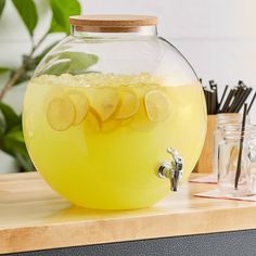 a glass pitcher filled with lemonade and ice