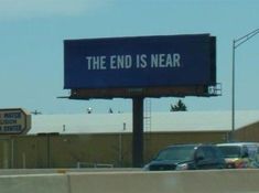 an advertisement for the end is near on top of a highway sign in front of a parking lot