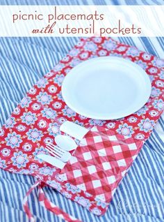 a red and white placemat with utensils on it next to a plate